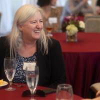 faculty at table with big smiles